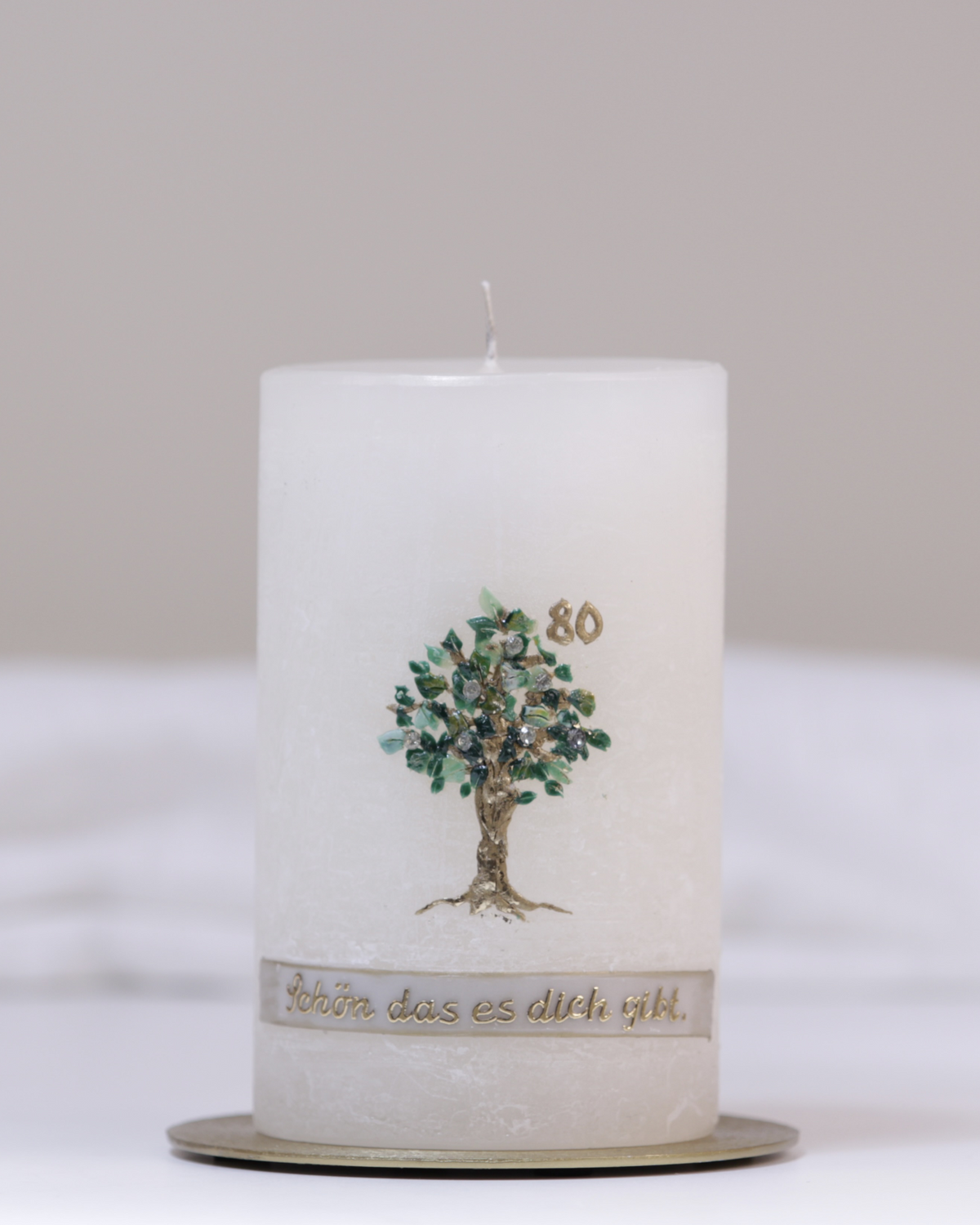 Geburtstagskerze in Elfenbein mit grün-goldenem Lebensbaum, goldener Jahreszahl und dem Schriftzug ‚Schön, dass es dich gibt‘ – handgegossen und personalisierbar.