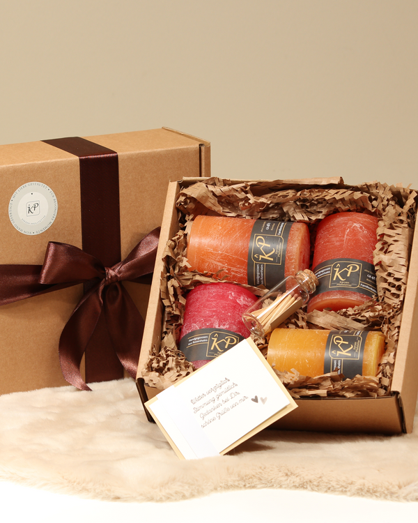 Geschenkbox mit vier Tischkerzen in Herbstfarben – Sonnengelb, Orange, Hellorange und Sommerrot – mit Streichhölzern und Karte