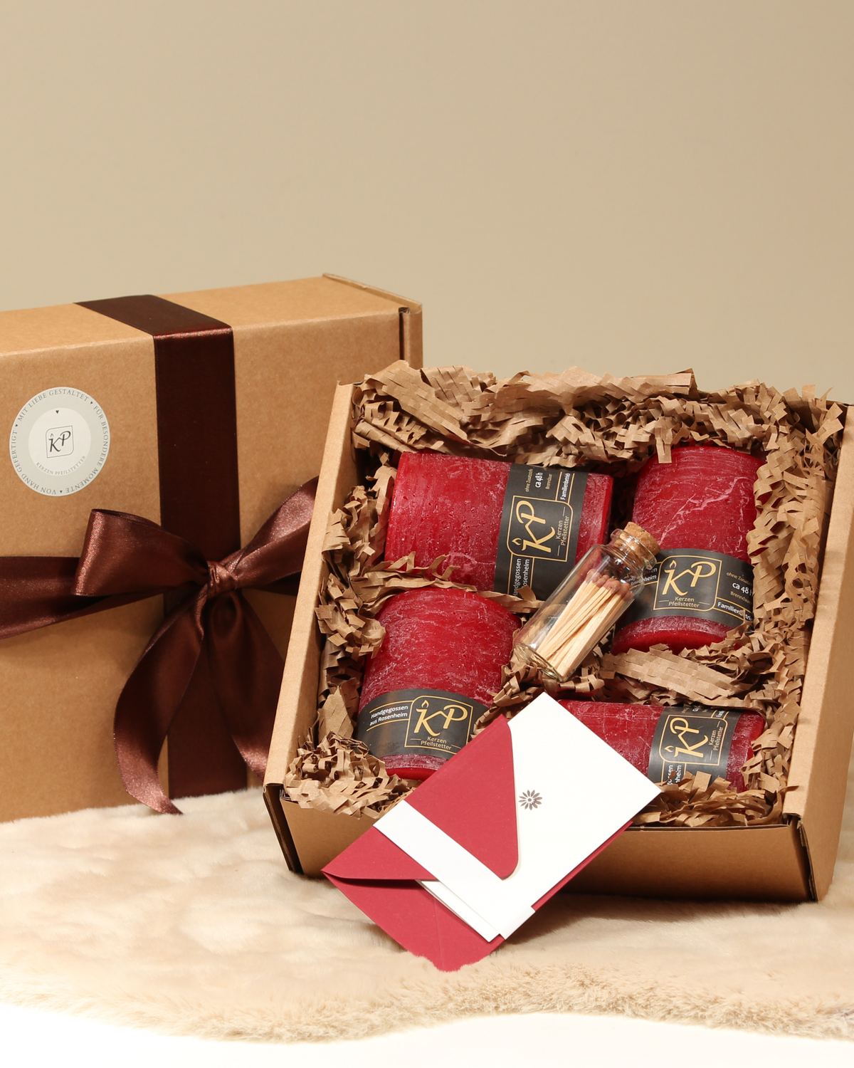Geschenkbox mit vier Tischkerzen in Weihnachtsrot, Streichhölzern und Karte