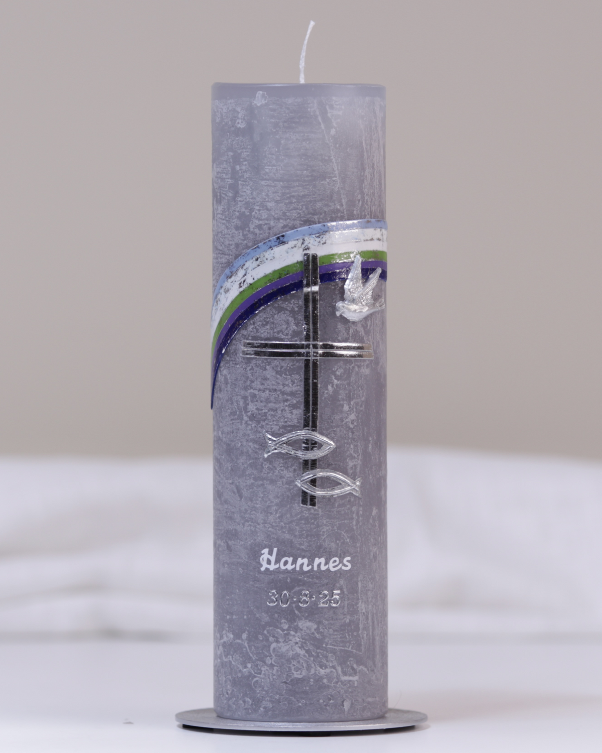 Graue Taufkerze mit silber-blauer Verzierung aus Kreuz, Fisch, Taube und Regenbogen.