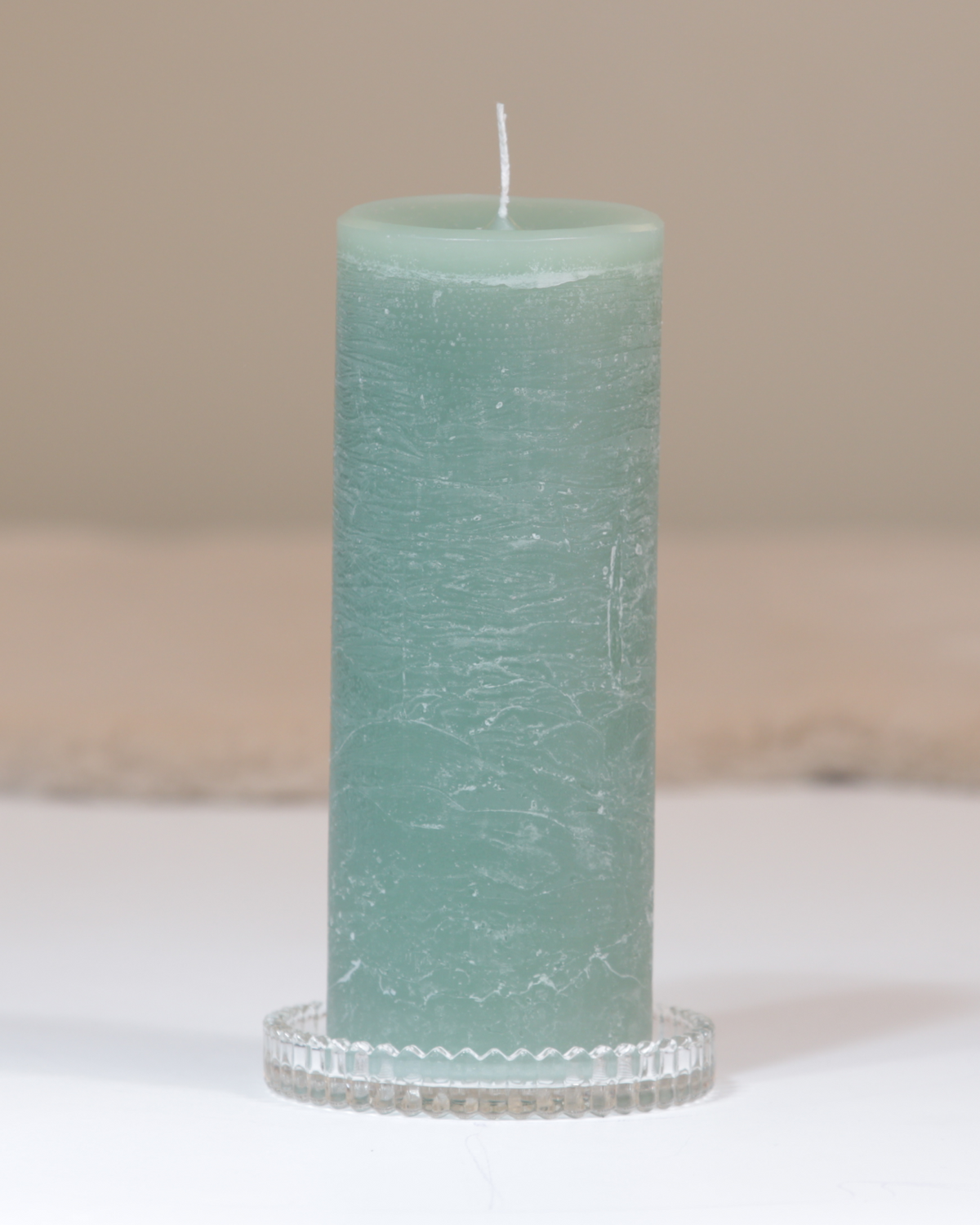 Kerzenteller aus klarem Glas mit facettierter Struktur mit Kerze.