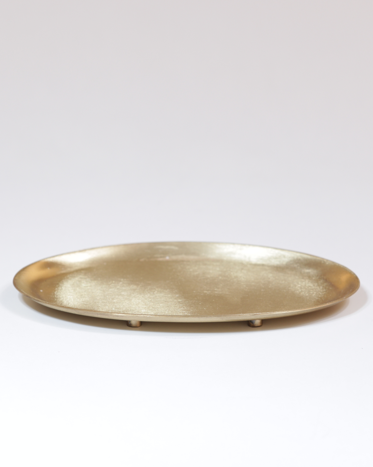 Kerzenteller aus Messing, oval, mattgoldfarben.